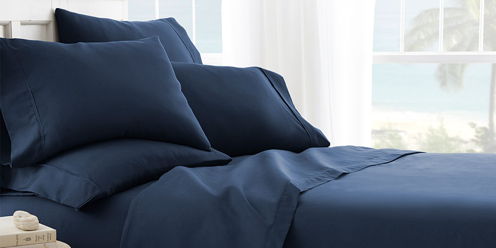 A bed with navy sheets