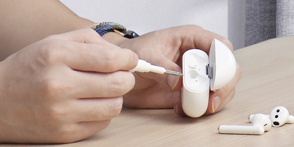 Someone is cleaning an airpods case with a tool 