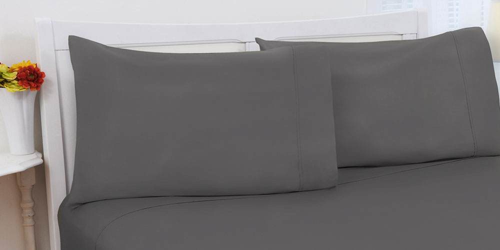 A bed with gray pillows